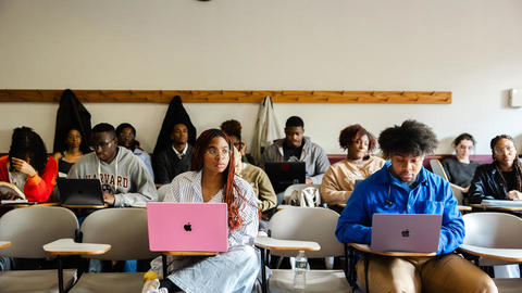 Students type notes on their laptops during a lecture in Sever Hall.