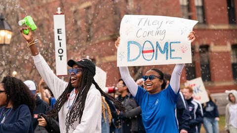 Students from Eliot House storming the Yard with their homemade signs, one saying "They're Coming DOME."