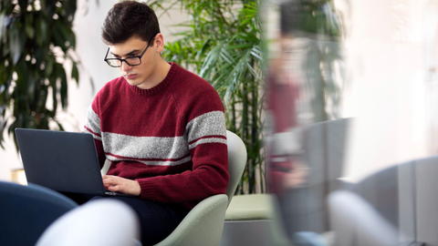 A student focuses on their laptop