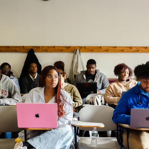 Students type notes on their laptops during a lecture in Sever Hall.
