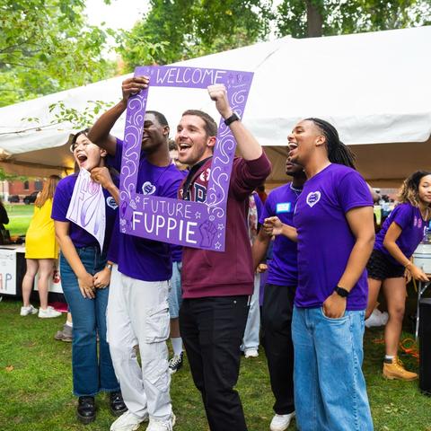 Student leaders from the First-Year Urban Program pose for a photo with a purple FUP photo frame during pre-orientation move-in.