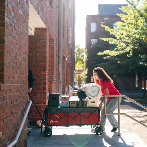 Student moving into Canaday using a wagon.