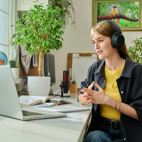 Student in headphones having video chat online on computer