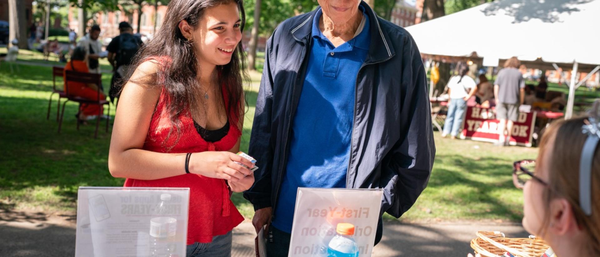 A student and her parent get information from the info desk at first-year move-in in the Yard.