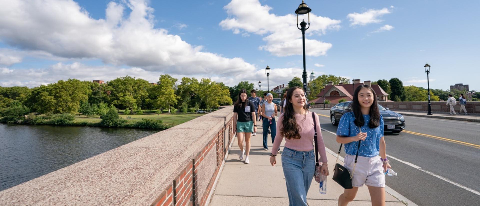 Students cross the bridge to the Harvard Athletics Complex during a nice summer day.