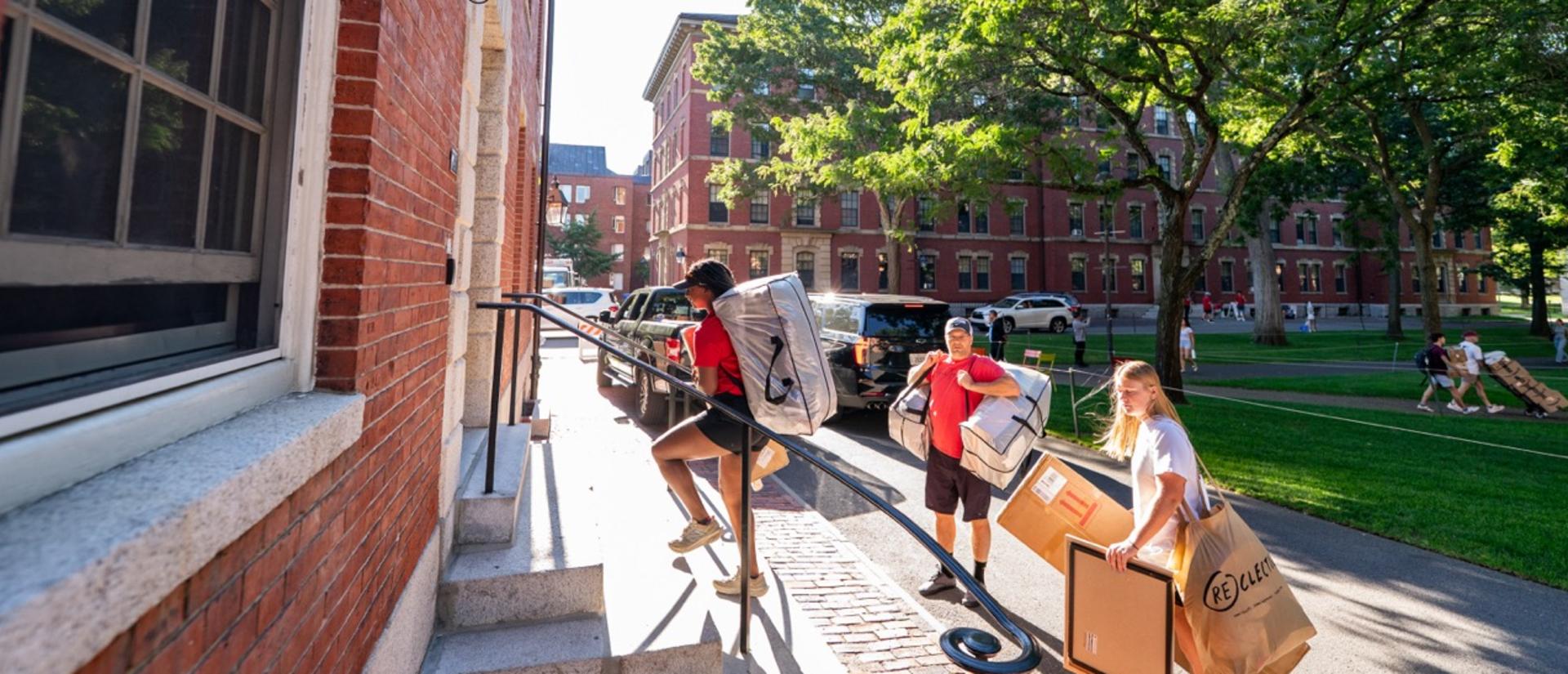 Students and parents move packages and boxes into Greys Hall during first-year move-in.